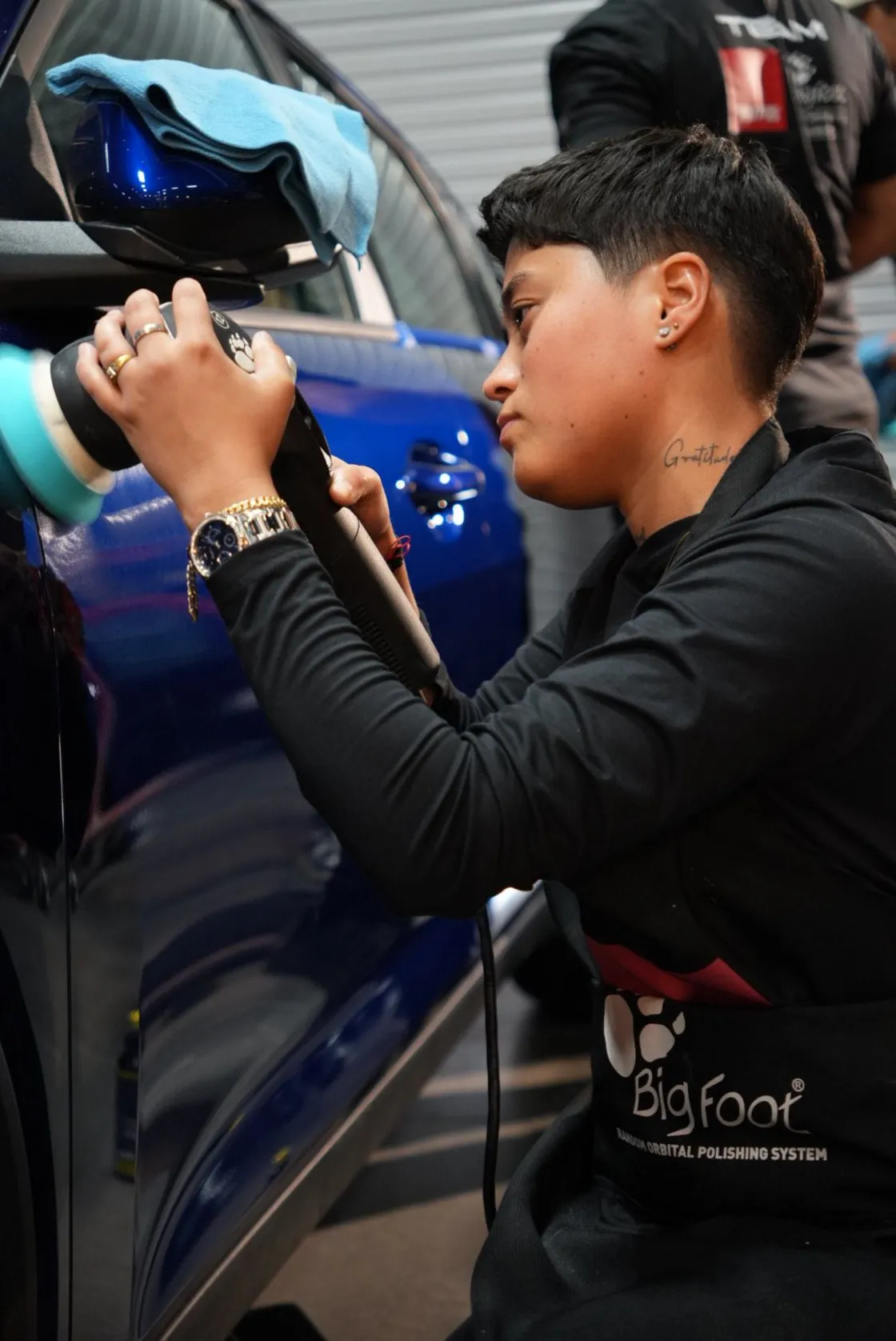 Auto Detailing Pro technician machine polishing a blue car with a RUPES orbital polisher in Dallas TX